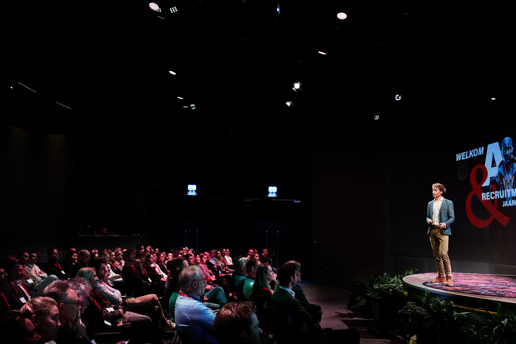 Laurens Waling op het podium in een volle, donkere theaterzaal